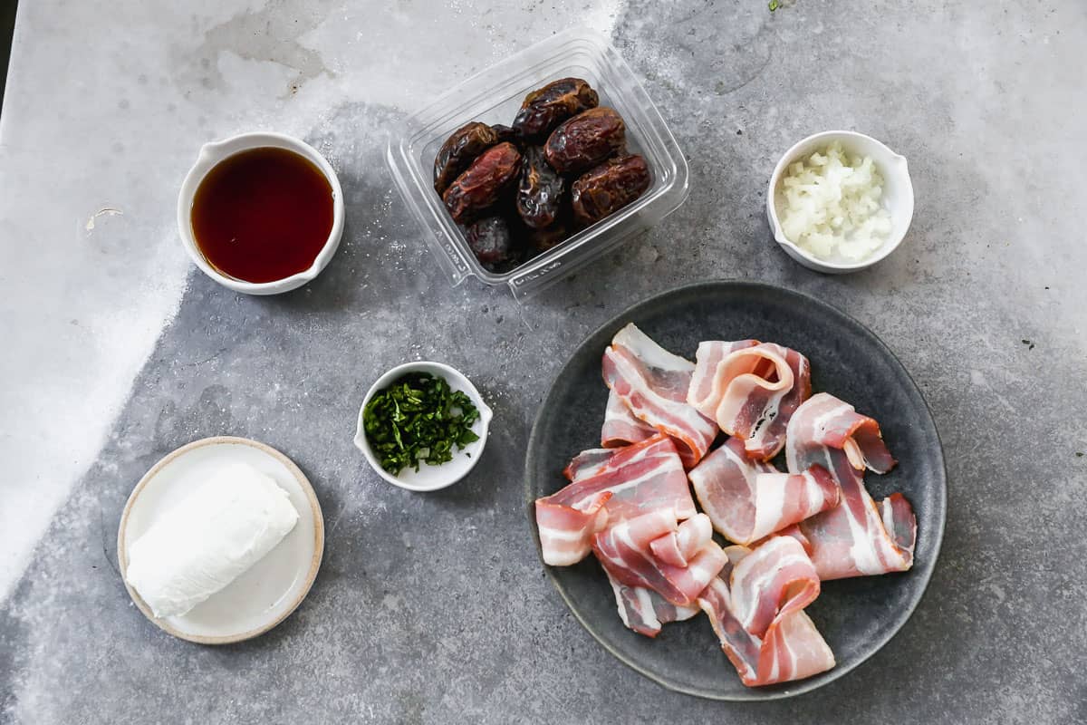 The ingredients needed for the best bacon wrapped dates recipe: bacon, goat cheese, dates, maple syrup, sweet onion, and cilantro.