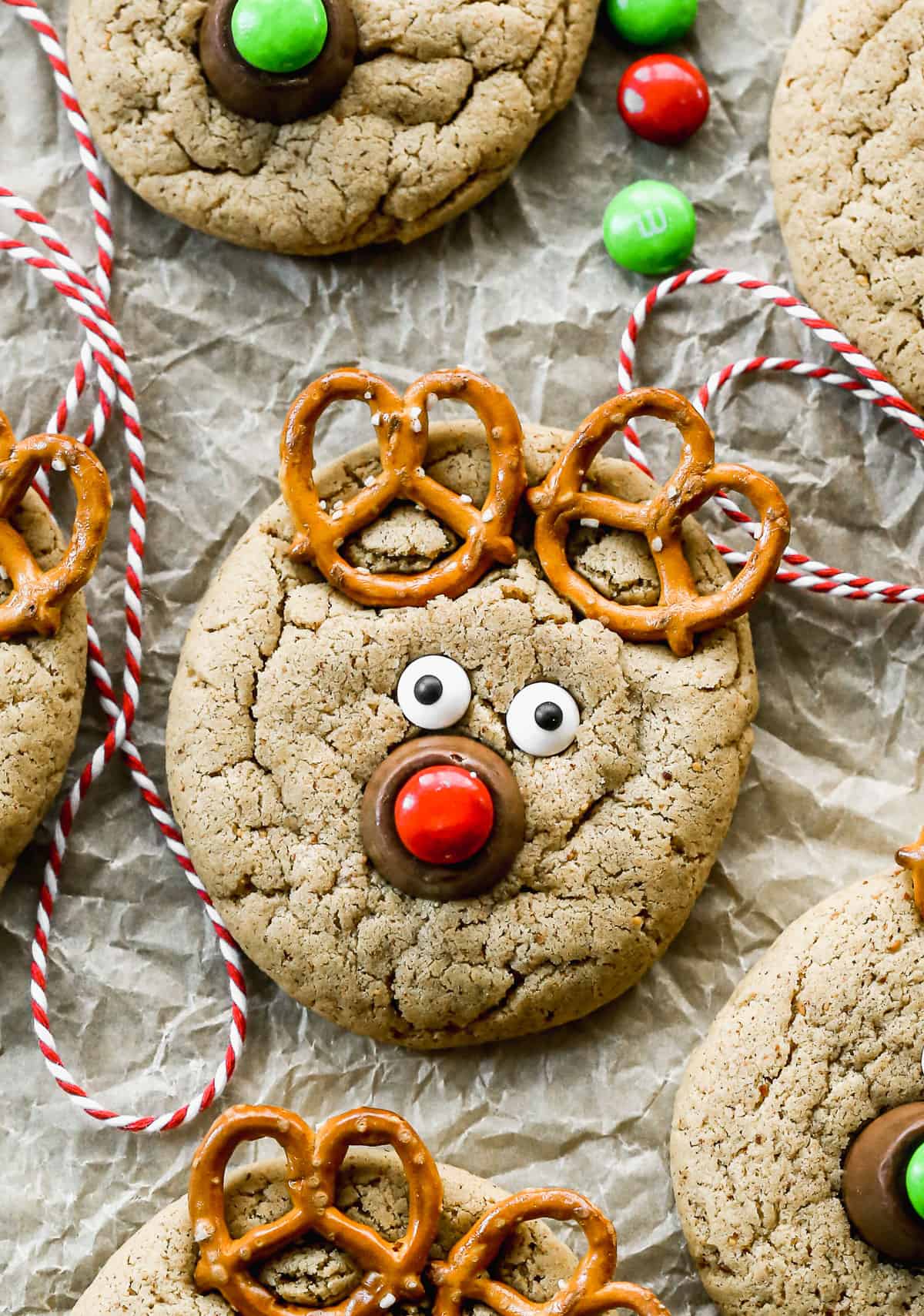 A Reindeer Cookie made with pretzels, candy eyes, a rolo, and a red m&m.