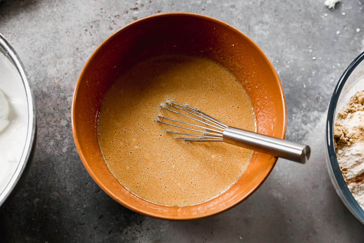 A mixing bowl with egg yolks, milk, greek yogurt, and molasses all mixed together. 