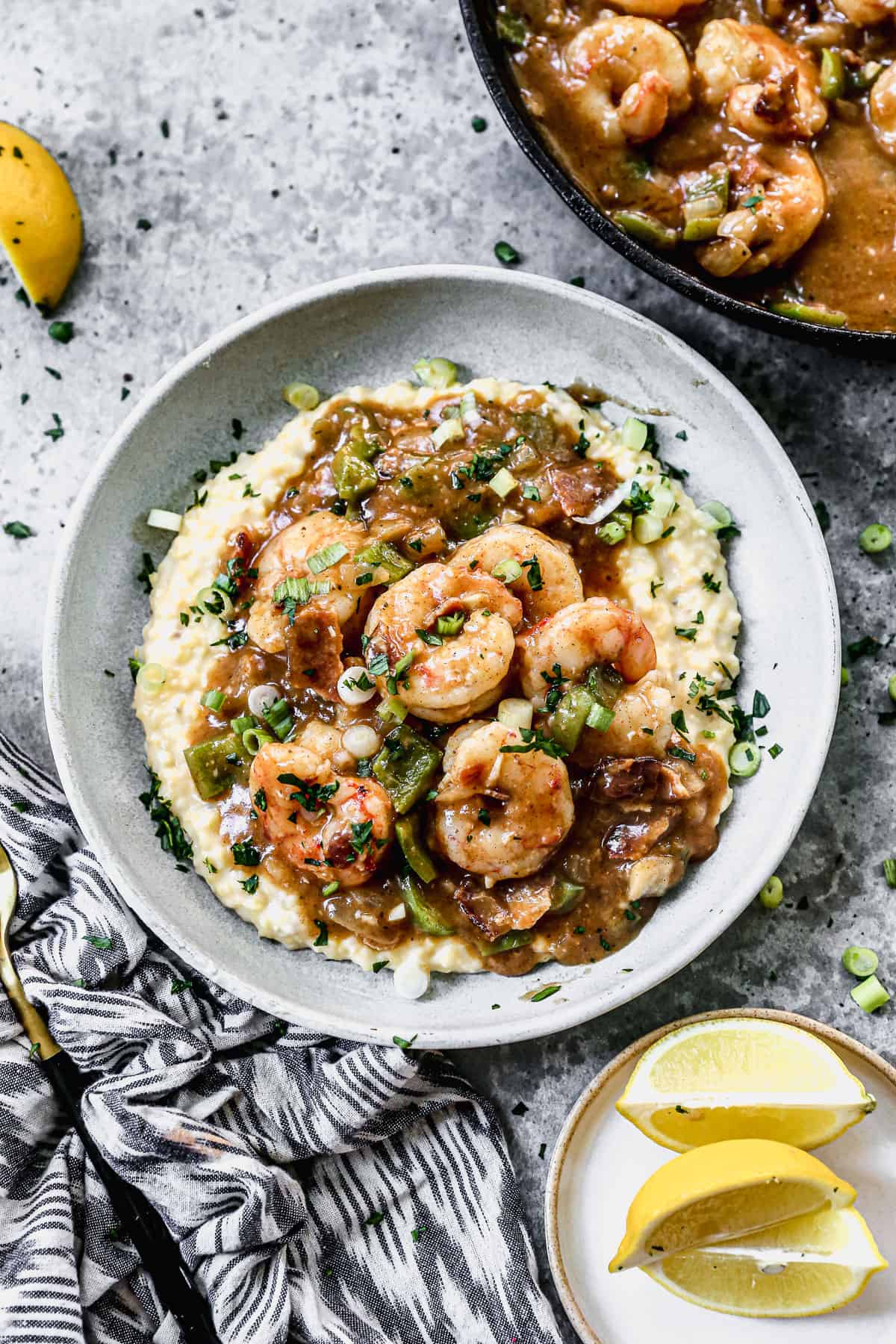A bowl filled with cheesy Shrimp and Grits and topped with green onions.