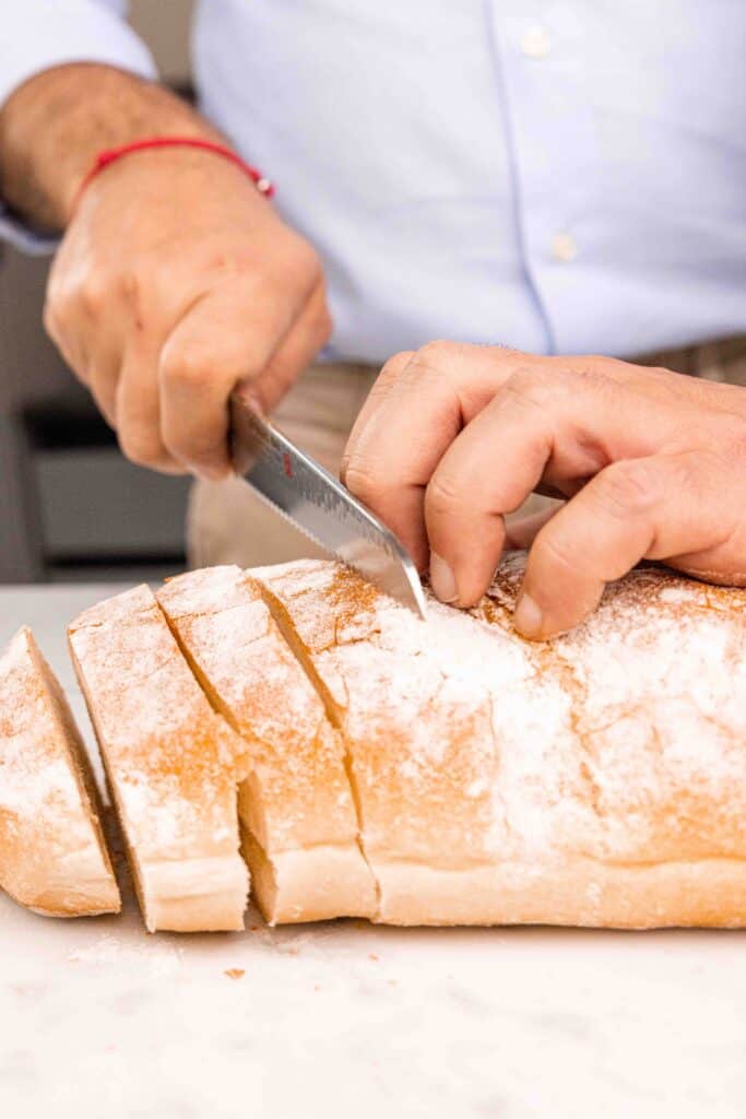 Slicing of a loaf of crusty bread.